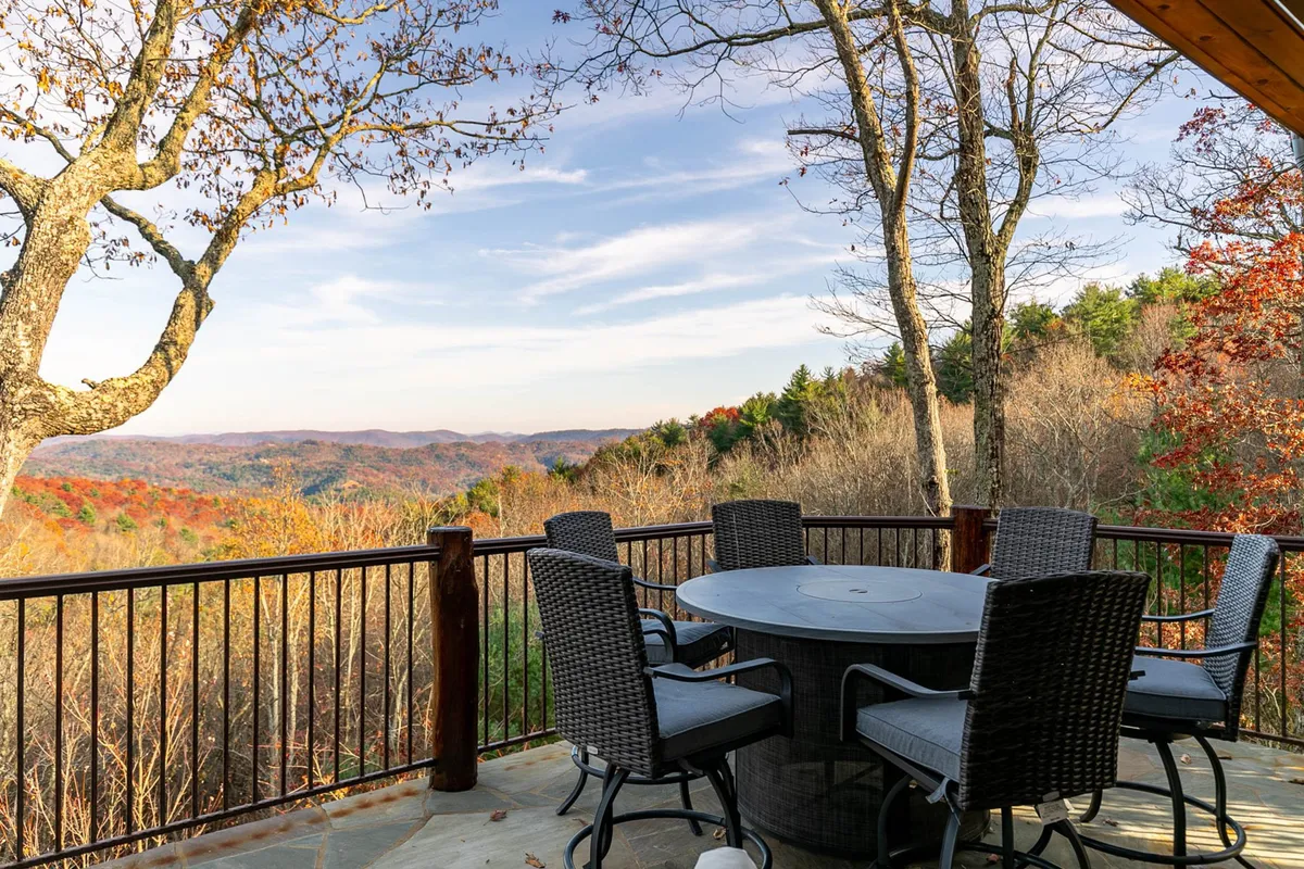 An outdoor dining table set amidst surrounding trees, with a sweeping mountain view as the backdrop. The scene is serene, inviting, and emphasizes outdoor living and relaxation in nature.