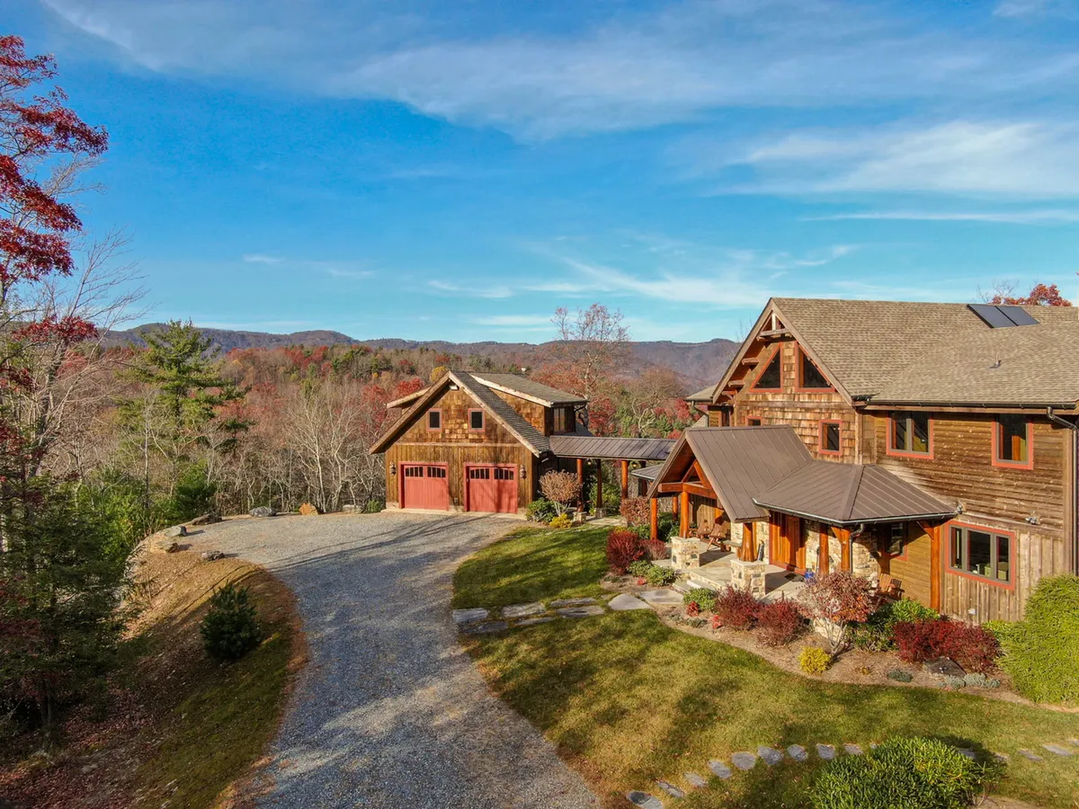 This image showcases the main house of Bailey's Creek Lodge, featuring a well-maintained garden, a spacious driveway, and the scenic mountain backdrop. The exterior emphasizes the property's integration with its natural surroundings and hints at opportunities for outdoor gatherings, relaxation by the fire pit, and seasonal enjoyment.